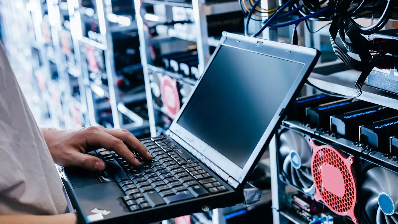 Person working on a laptop in a server room