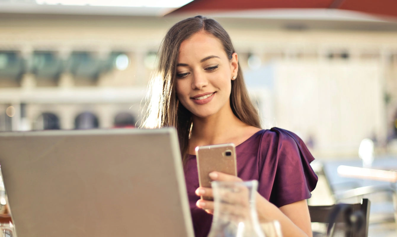 woman using computer and cellular device