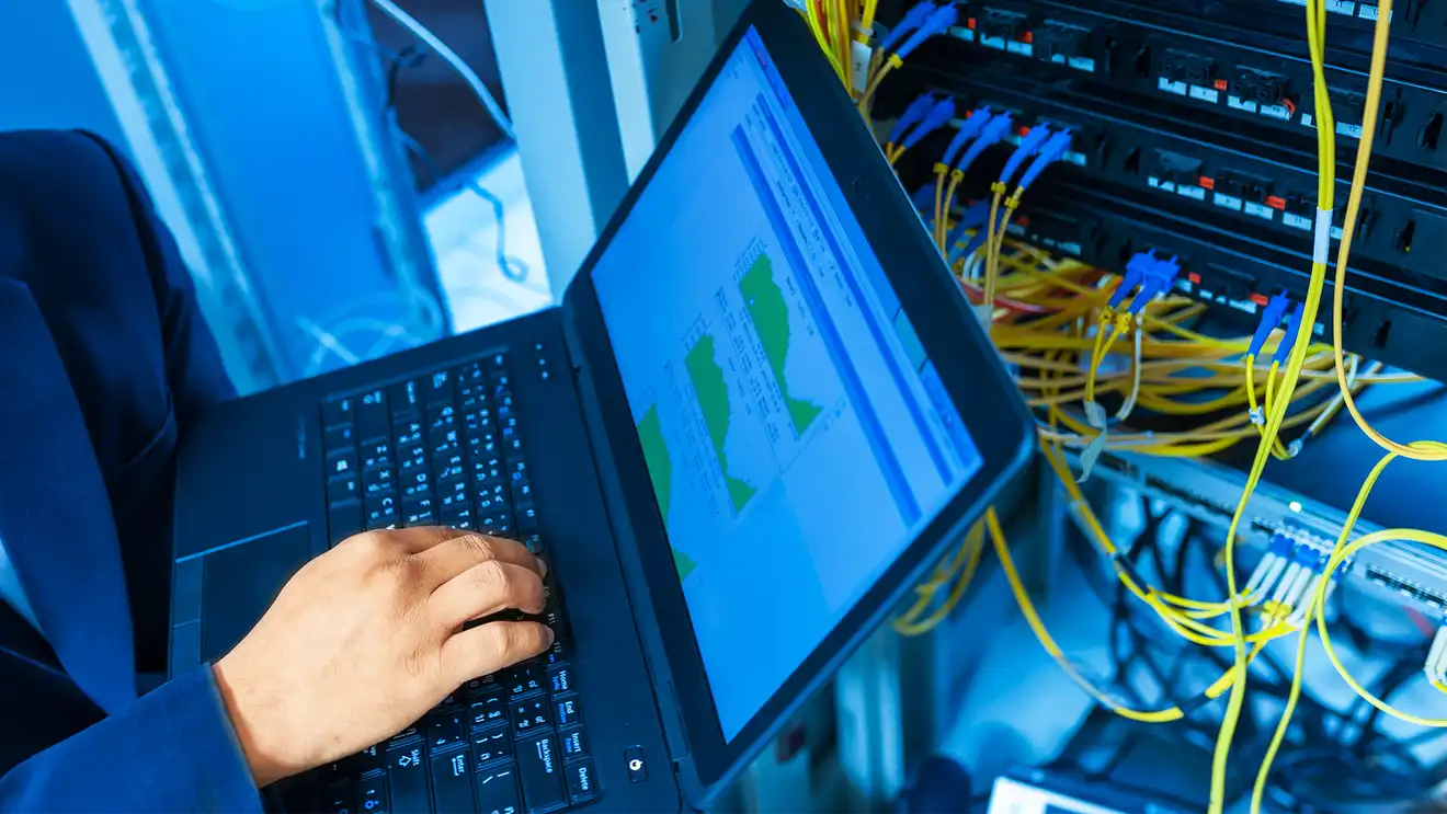 laptop open with chords for networking attached